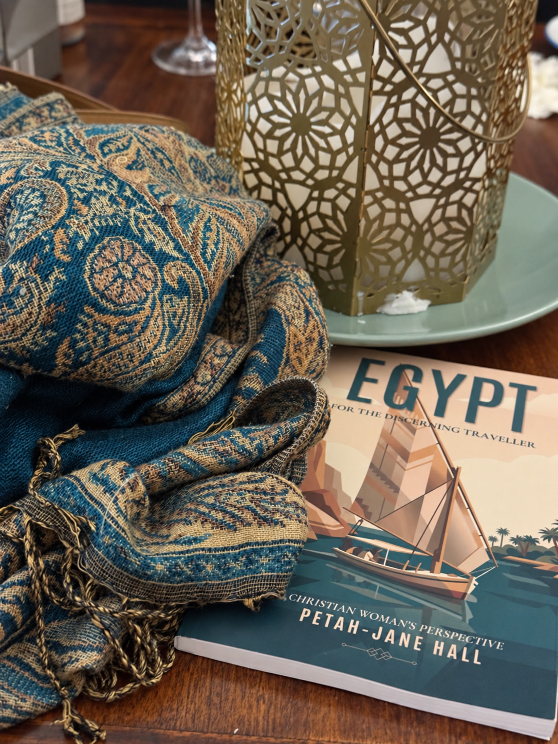 Egypt for the Discerning Traveller by Petah-Jane Hall beside a teal Egyptian textile and lantern